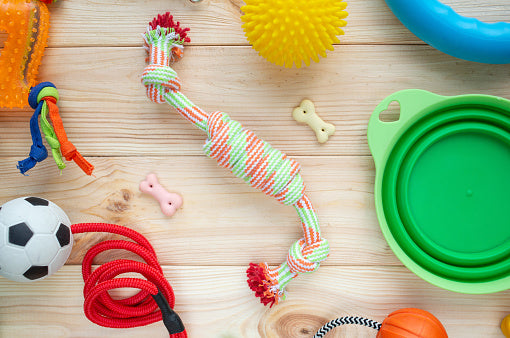 some pet toys including a tug rope, a bottle, a stuffed chicken and a pet bowl